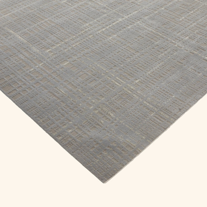 Textured rug with geometric pattern in muted monochromatic color tone.