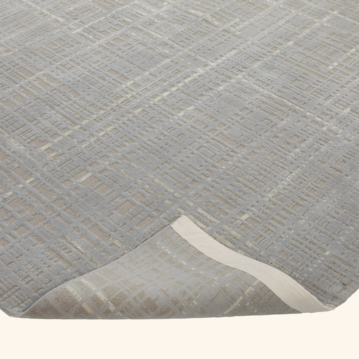 Close-up of textured rug with geometric design, 3D effect, neutral colors.