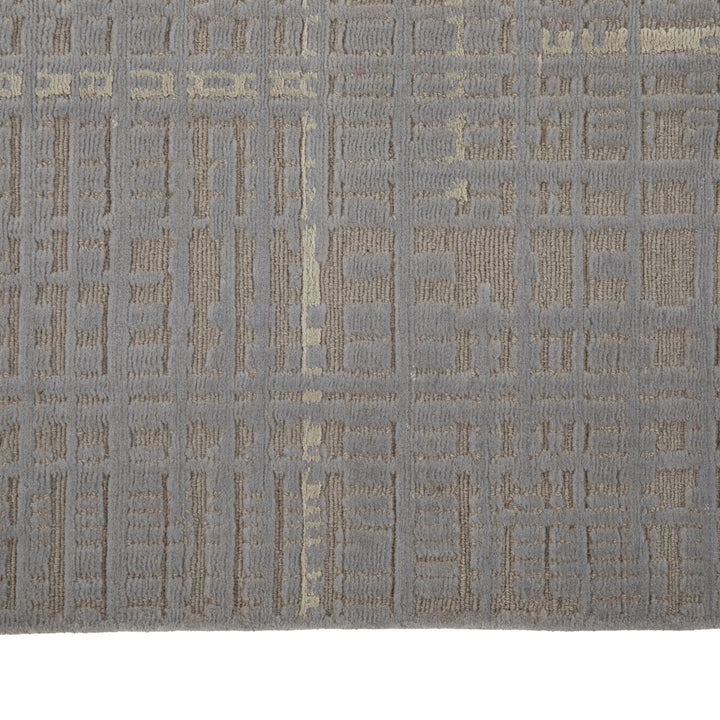 Muted grey and tan carpet with grid pattern, showing wear.