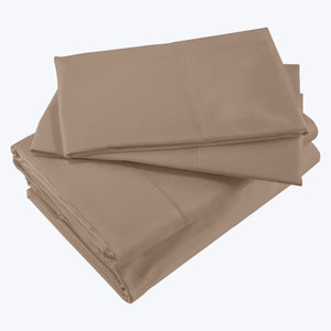 Crisp, clean, and luxurious cream-colored bed sheet set stacked neatly. - hover