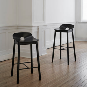 Modern minimalist bar stool with light wood finish and metal footrest. - hover