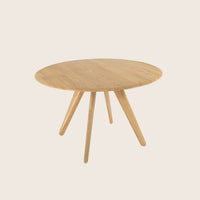 Round wooden coffee table with three legs and natural wood finish