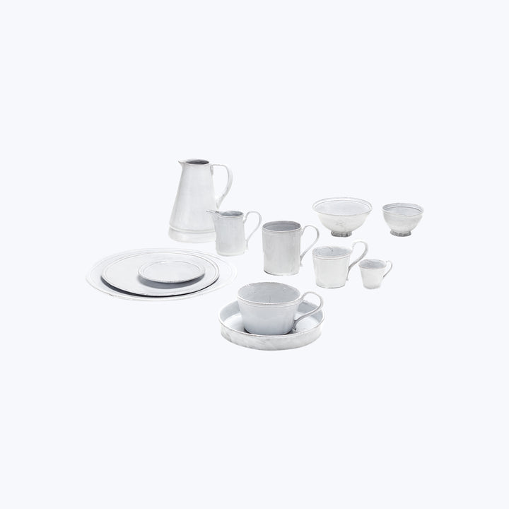 Minimalist white ceramic tea set against bright background, orderly arrangement.
