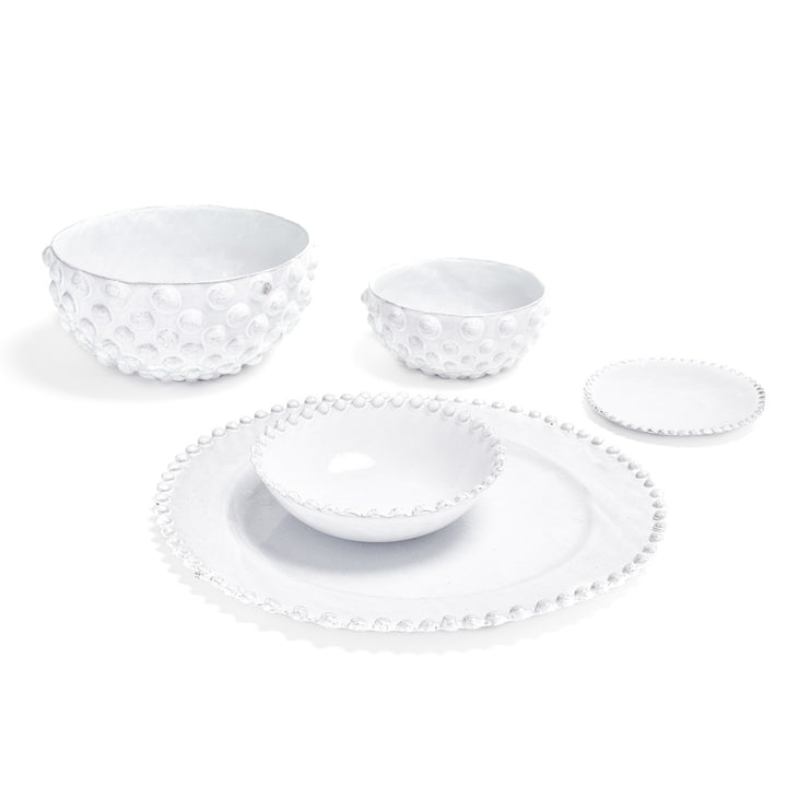 Elegant white ceramic dinnerware set with dotted bubble-like pattern edges.