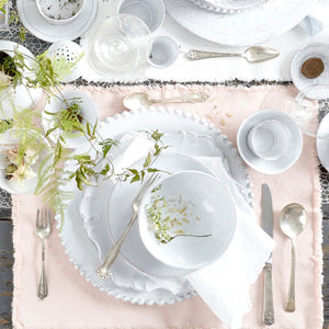 Elegant white plate with textured edge design on white background. - hover