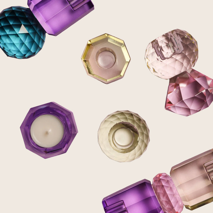 Colorful geometric decorative objects resembling gemstones sparkle on purple background