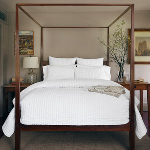 High-quality cream blanket with ribbed quilting, folded for display. - hover
