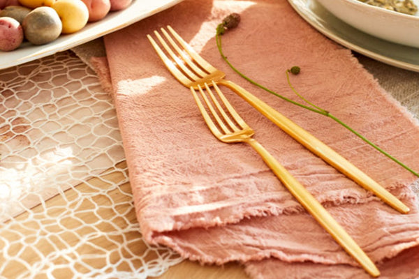 Festive spring dining setup featuring delicate golden forks and decorative eggs.