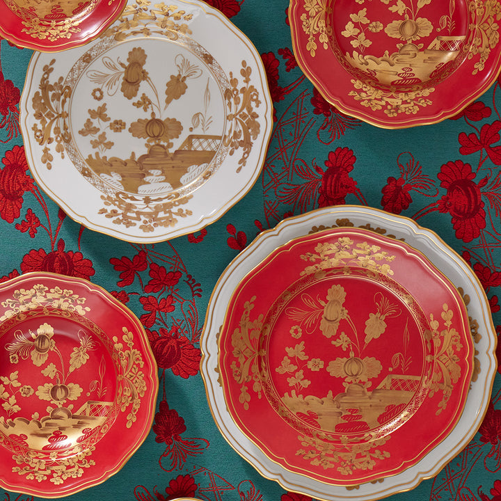 Traditional red and white decorative plates on floral fabric background.