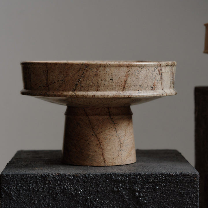 Handcrafted ceramic vessel with unique design on textured black base.