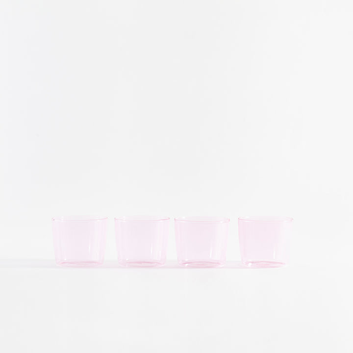 Four pink-tinted cups in a minimalist, serene composition on white.