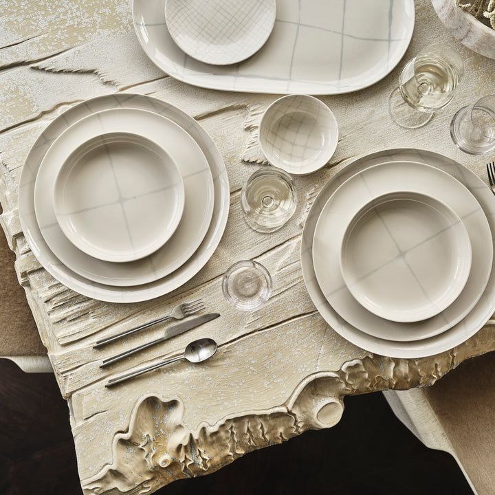 Elegantly set dining table with rustic wooden surface, chic tableware.