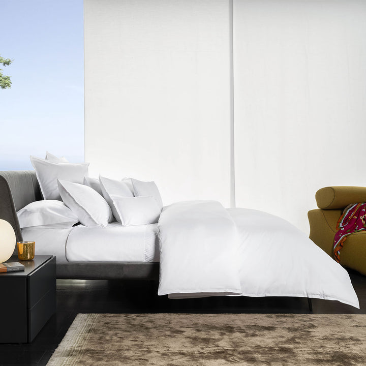 Modern bedroom with neutral tones, cozy furnishings, and natural light