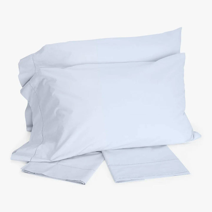 Set of light-colored bedding including pillowcases, sheet or duvet cover.