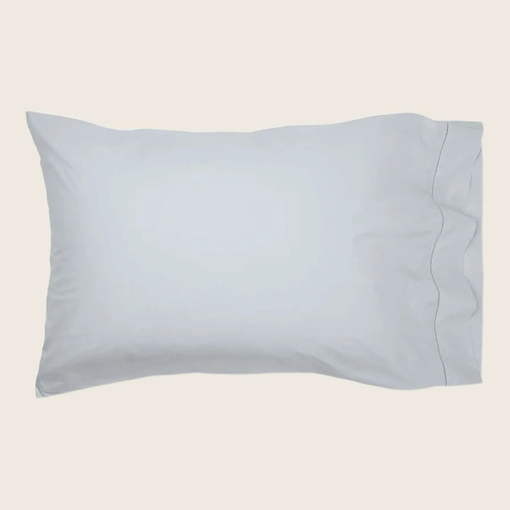 Simple grey pillowcase with stitched border on white background.