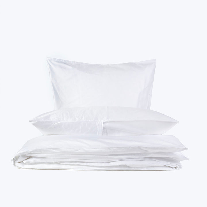 Crisp white bedding items, including pillow and duvet, isolated. Clean.