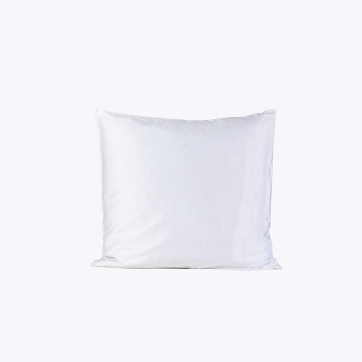 Soft, white square pillow on plain background, minimalist aesthetic.