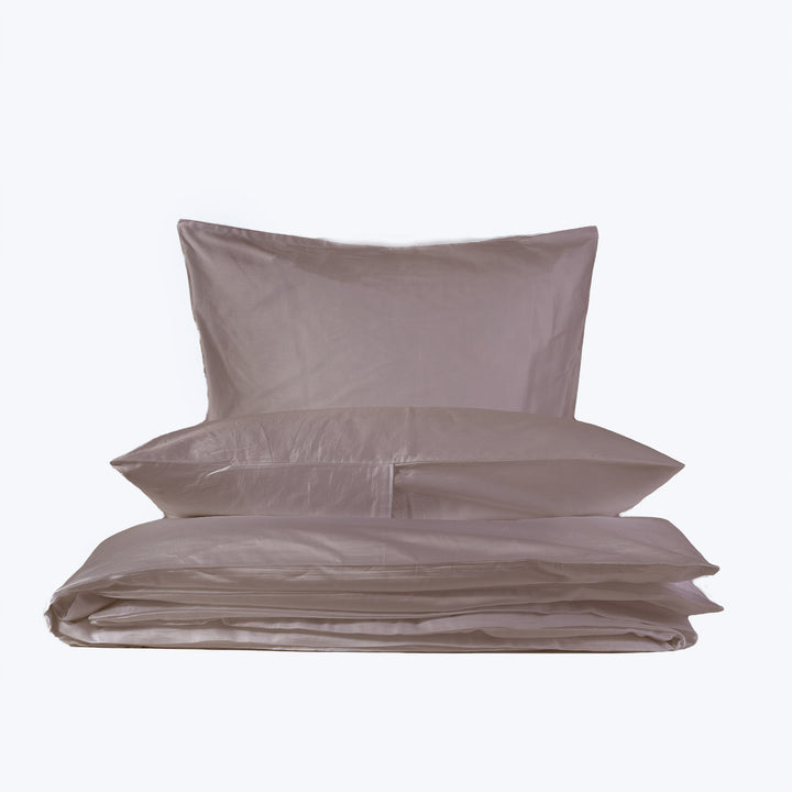 Neatly folded bed linens in light gray on white background.