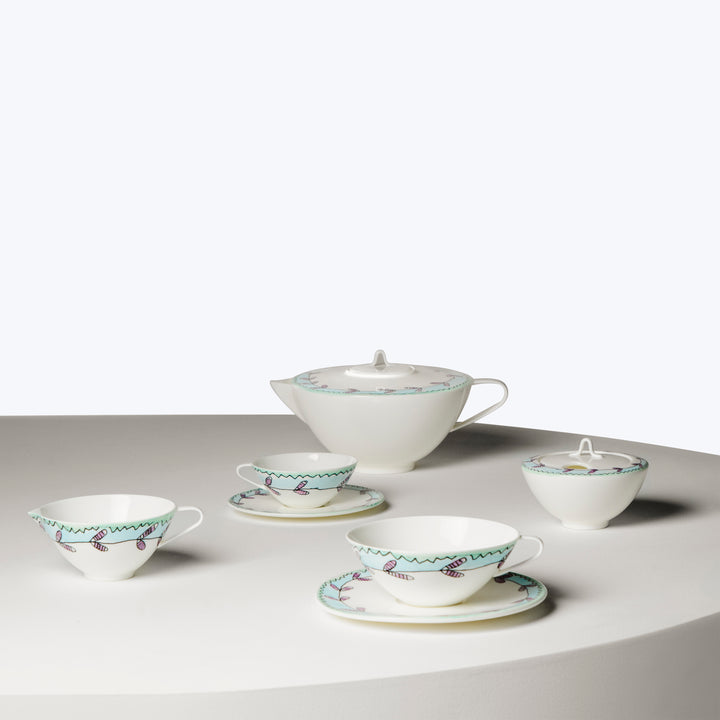 Modern porcelain tea service set with geometric patterns in blue/pink.