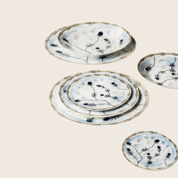 Elegant botanical-themed ceramic plates in blue and gold accents.