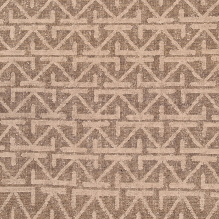 Geometric arrow-like pattern on off-white fabric with dark background.
