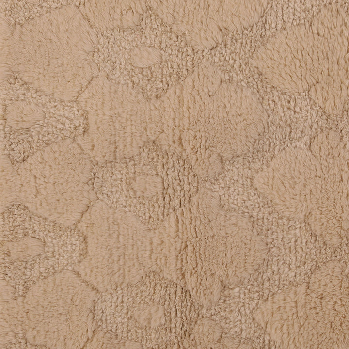 Soft, plush beige textured surface with swirling organic pattern design.