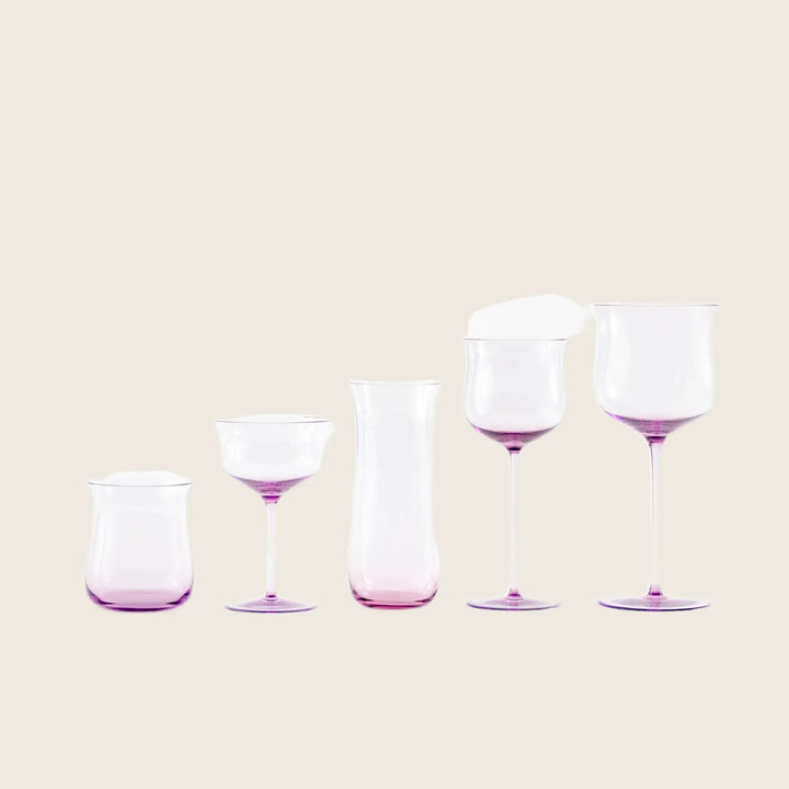 Minimalist arrangement of purple-tinted glassware against white background.