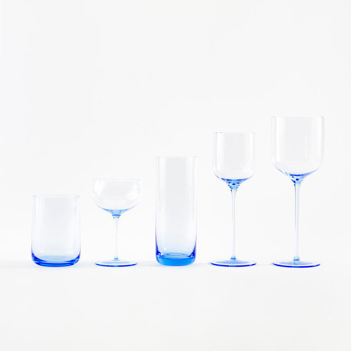 Collection of five clear glass vessels with blue-tinted bases.