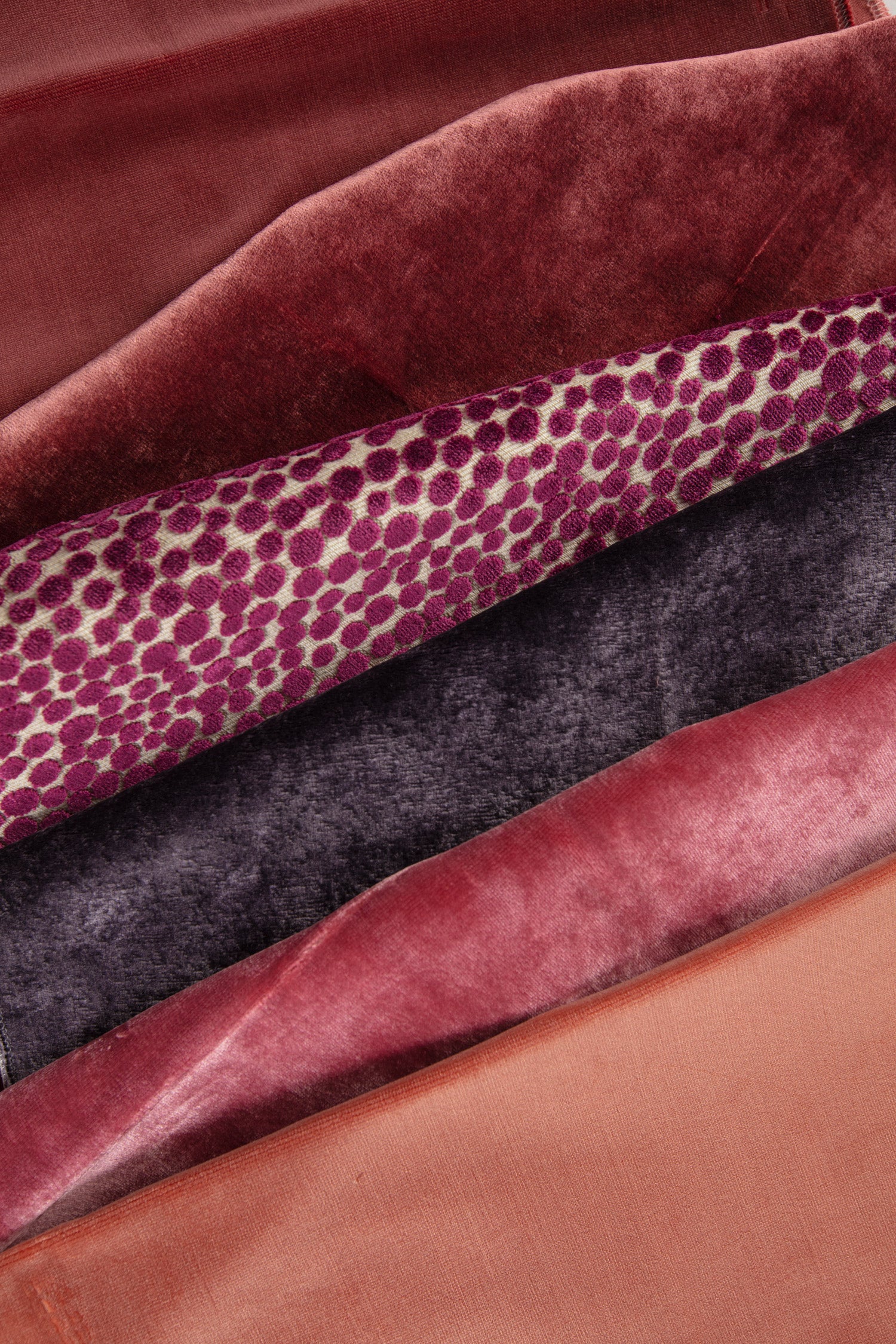 Luxurious fabric swatches in crimson, velvet, and patterned textures.
