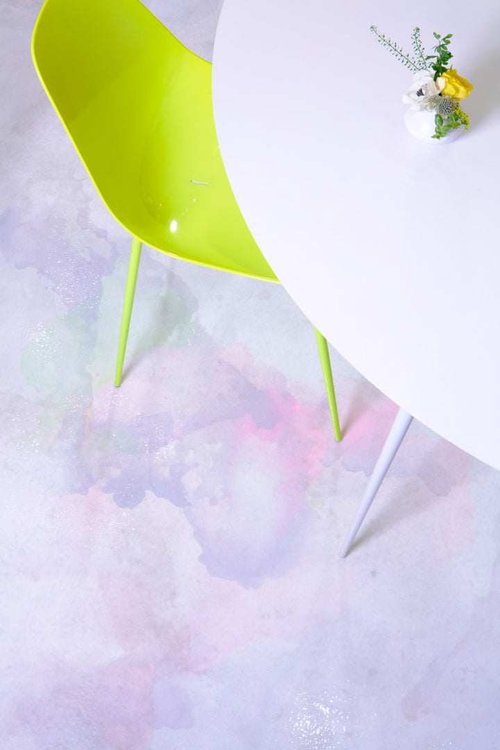 Modern setting with green chair, white table, and vibrant decor.