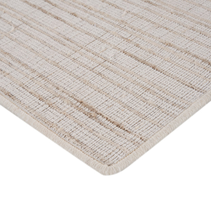 Close-up of textured rug with ribbed stripes in neutral beige.