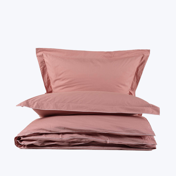 Set of pink bedding with pillows and duvet cover arranged