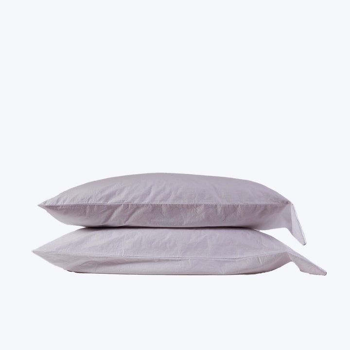 Two plump lavender pillows stacked on white background, product display