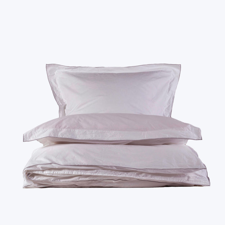 Crisp white bedding set with pillows on white background display.