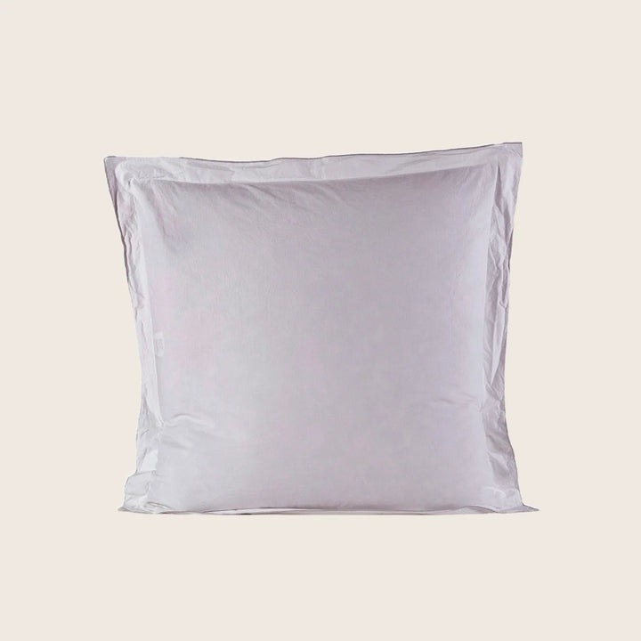Fluffy square pillow in smooth white pillowcase, minimalist design.