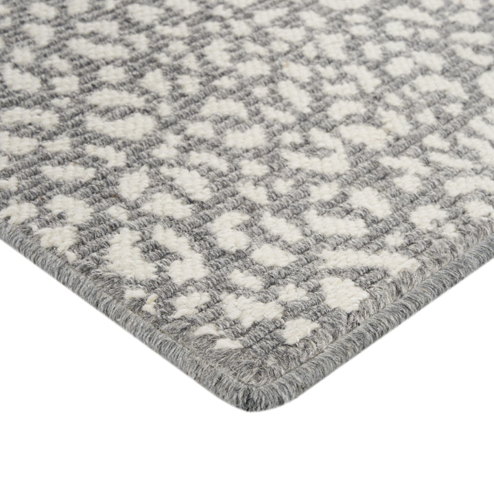 Close-up of textured gray and white rug with geometric pattern.