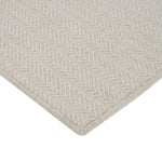 Close-up of light beige textured rug with herringbone pattern.