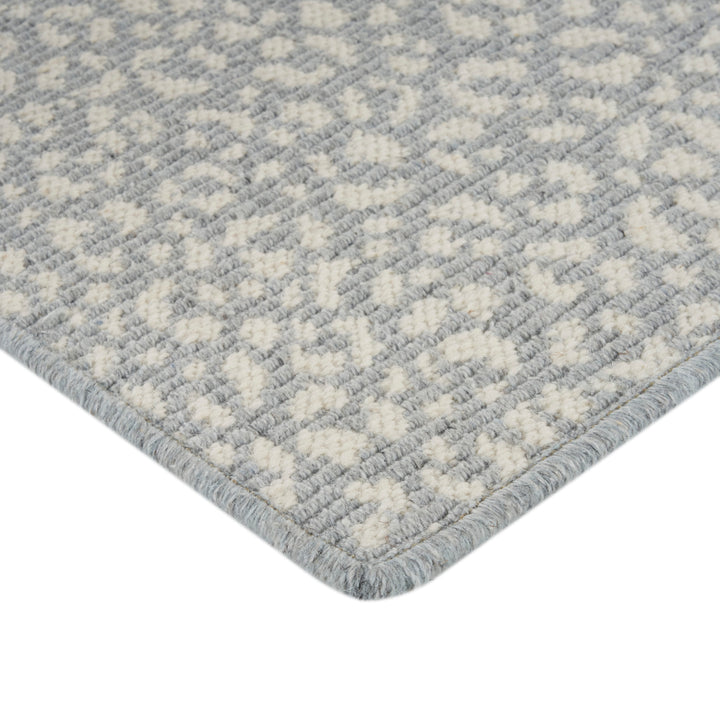 Close-up of plush, textured carpet with geometric cream and grey design