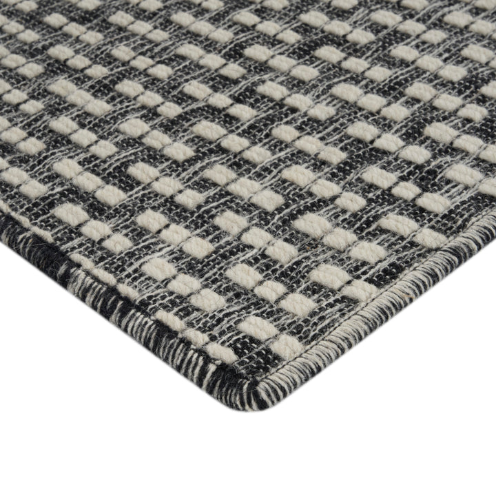 Close-up of durable woven rug with grid texture in neutrals.