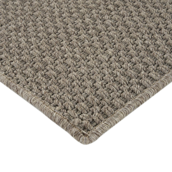 Close-up of intricately woven brown rug with neat border design.