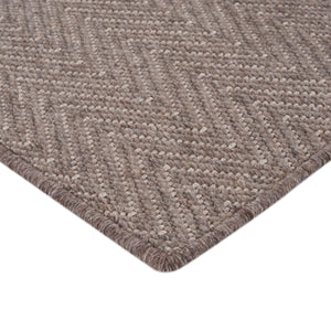 Close-up of textured beige rug with raised chevron pattern. - hover