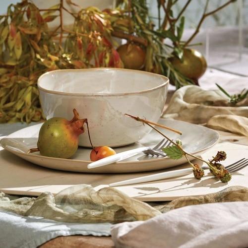 Rustic table setting with autumnal elements creates cozy dining atmosphere.