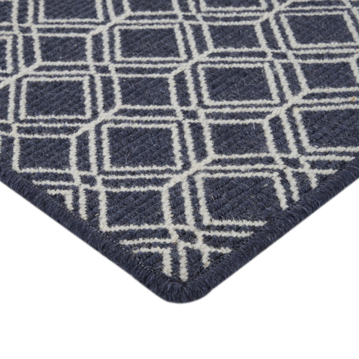 Close-up of contemporary geometric navy blue rug with cream accents.