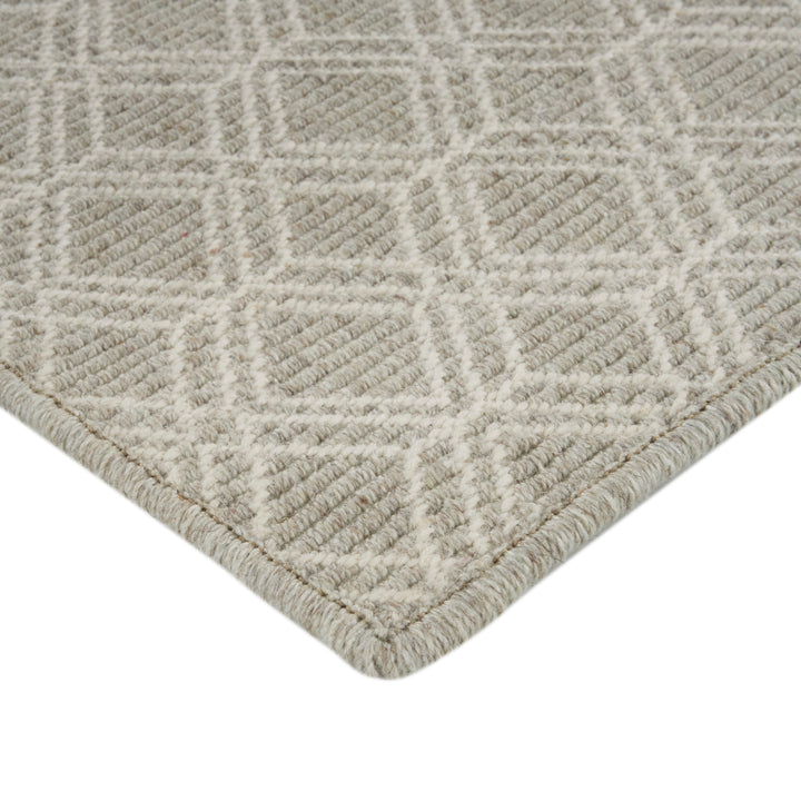 Close-up of high-quality beige textured rug with geometric pattern.