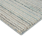 Close-up of soft, thick tufted textile in shades of grey.