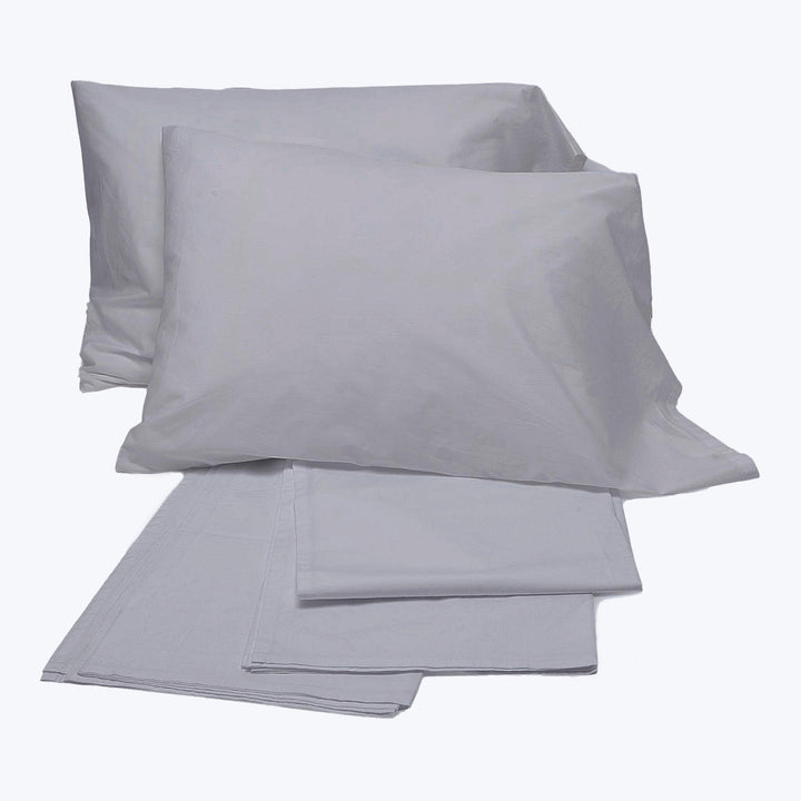 Simple and elegant light grey bed linens on white background.