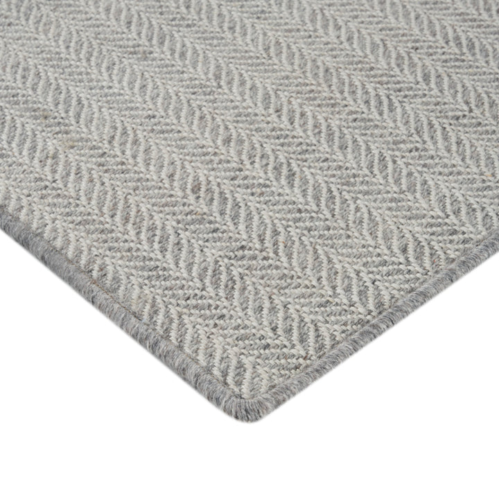 Close-up of herringbone pattern textile in light grey color.