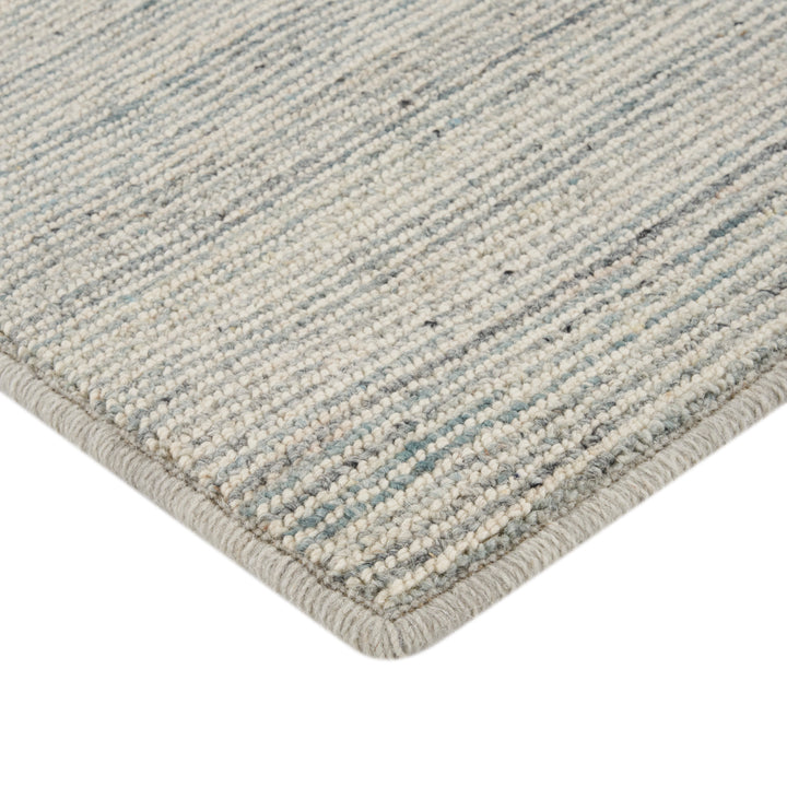 Close-up of intricately woven neutral striped rug with blue accents.