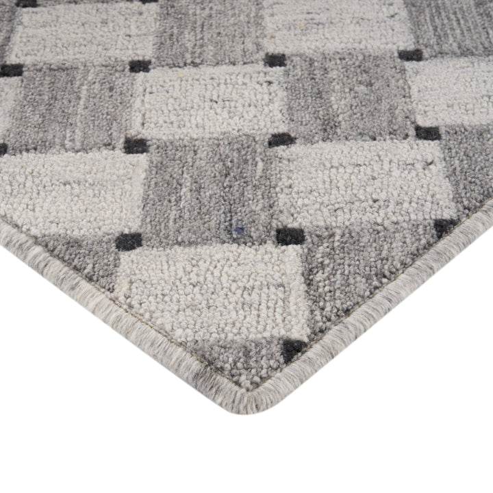 Close-up of modern gray geometric carpet corner with thick pile