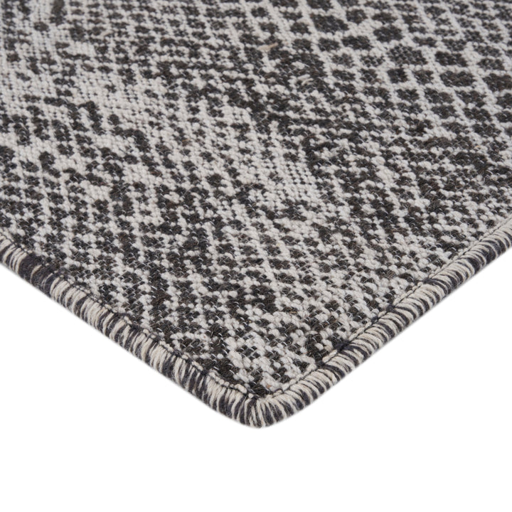 Close-up of houndstooth pattern on textured fabric, black and white.